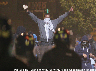 顔を覆い、警官と対峙する暴徒